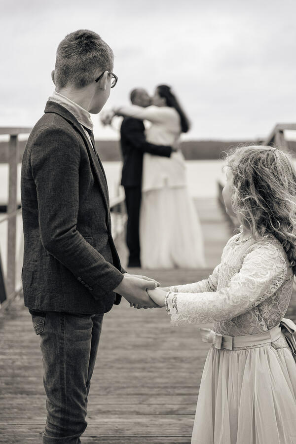 Zwei Personen stehen sich gegenüber und halten sich an den Händen während eines ruhigen Moments bei der Zeremonie.