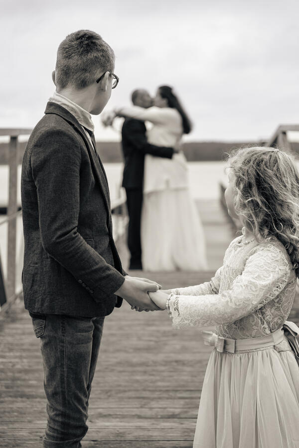 Zwei Personen stehen sich gegenüber und halten sich an den Händen während eines ruhigen Moments bei der Zeremonie.