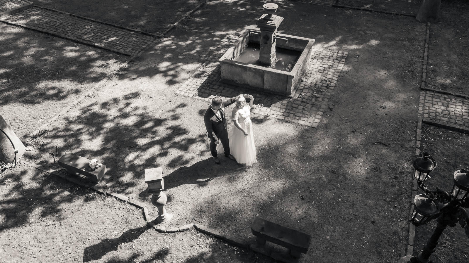 Hochzeitsfotografie im Malepartus Bargteheide – Drohnenaufnahme des tanzenden Brautpaars am Brunnen in Schwarzweiß von MomentTraum Fotografie.