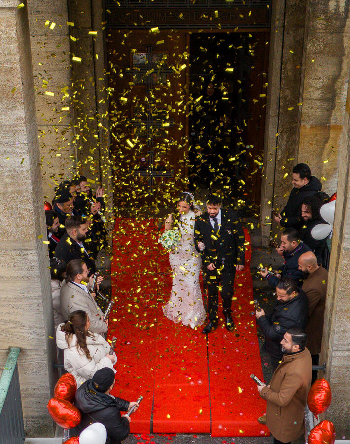 Hochzeitsmoment mit goldenen Konfetti Emotionale Augenblicke, festgehalten im perfekten Timing – der große Auftritt des Brautpaares auf dem roten Teppich.